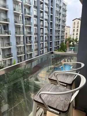 a balcony with two chairs and a swimming pool at Cozy Haven Across Terminal 3 in Manila