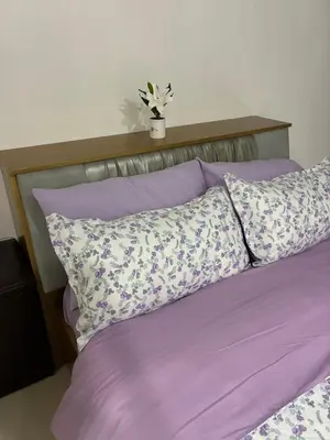 a bed with purple sheets and a potted plant on top at Cozy Haven Across Terminal 3 in Manila
