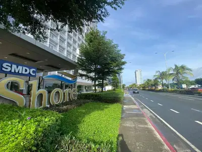 a sign on the side of a building next to a road at Shore 1 Spacious Smart Home 3C in Manila
