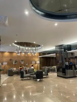 a lobby with couches and chairs and a chandelier at Japandi - Inspired Staycation MOA Pasay City in Manila