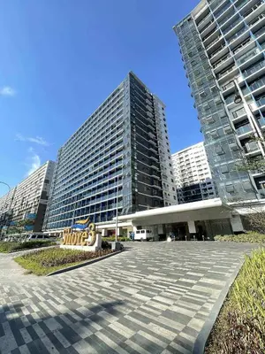 a large building with two tall buildings at Cabin and a cozy stay near MOA in Manila