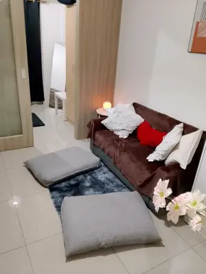 a living room with a brown couch with pillows at Ambulinog in Manila
