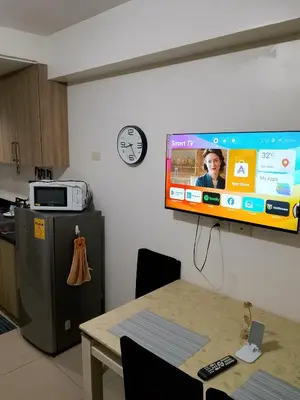 a television hanging on a wall in a kitchen at Ambulinog in Manila