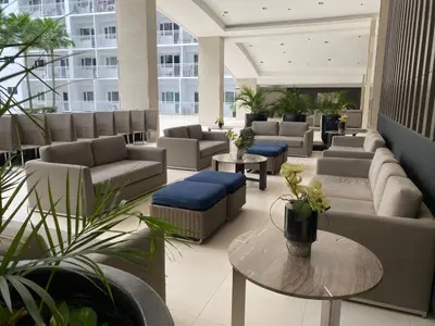 a lobby with couches and tables in a building at MOA Home For Family Trips & Getaways Kitchen-505 in Manila