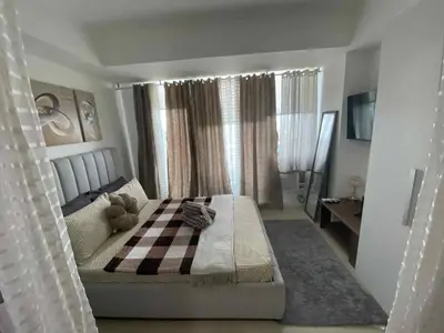 a bedroom with a bed with a checkered blanket on it at Condo in Paranaque City Homes Azure in Manila