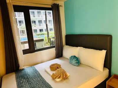 a bed with two towels on it with a window at Shore 3 Residences Poolside Room 245 by Prime Stay MOA in Manila