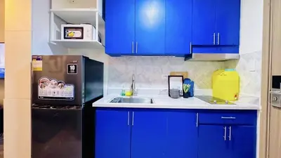 a kitchen with blue cabinets and a sink and a refrigerator at 2 Bedroom Rental Apartment in Pasay in Manila