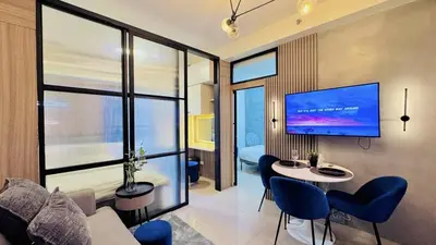 a living room with a couch and a tv on a wall at 2 Bedroom Rental Apartment in Pasay in Manila