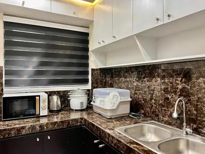 a kitchen counter with a sink and a microwave at Apartment Taguig Makati staycation with parking in Manila