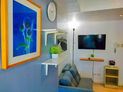a living room with a couch and a flat screen tv at Azure Place Maui 8th floor in Manila