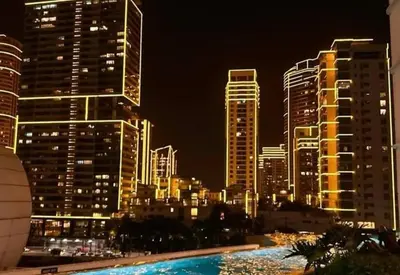 a city skyline with tall buildings at night at Novotel Rockwell View Hotel Residences in Manila