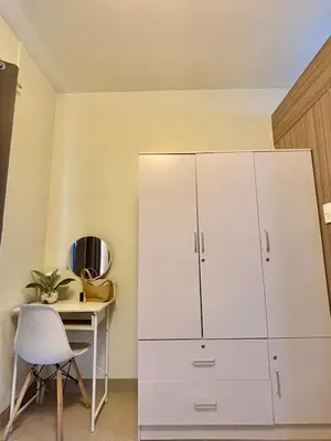 a white cabinet in a room with a table and a chair at Twin Unit at Shore 2 Residences in Manila