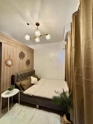 a small bedroom with a bed and a table at Twin Unit at Shore 2 Residences in Manila