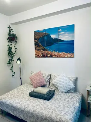 a bedroom with a bed with two paintings on the wall at Haven's Suites a place like home in Manila
