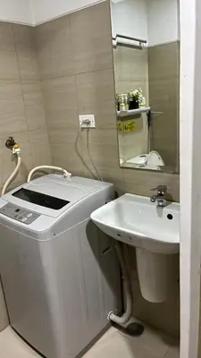 a white bathroom with a sink and a mirror at Haven's Suites a place like home in Manila