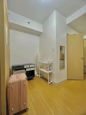 an empty room with a suitcase in a room at Taguig Condo Unit - Grace Residences by Jenn in Manila