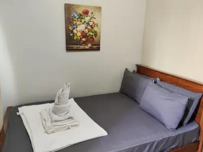 a room with a bed with a painting on the wall at Lhan residence in Manila
