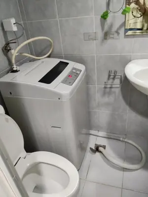 a small bathroom with a toilet and a sink at Lhan residence in Manila