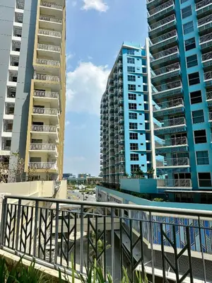 a view of two tall buildings from a balcony at The Bloom by Y&Y Condo at Bayshore Res Resort in Manila
