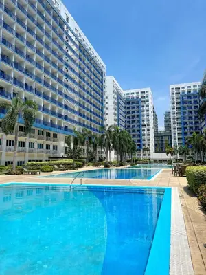a large swimming pool in front of a large building at New Cozy 2-bedroom deluxe condo for 5 pax in MOA in Manila