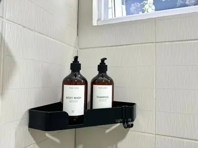 two bottles on a shelf on a bathroom wall at New Cozy 2-bedroom deluxe condo for 5 pax in MOA in Manila
