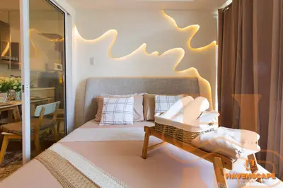 a bedroom with a bed and a table with a mirror at Havenscape Staycation in Manila