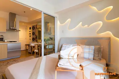 a bedroom with a large bed and a kitchen at Havenscape Staycation in Manila