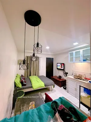 a living room with a bed and a kitchen at Paco Manila Rental Studio Unit in Manila