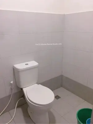 a bathroom with a white toilet in a room at Paco Manila Rental Studio Unit in Manila