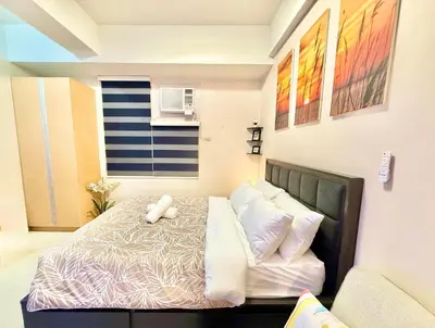 a bedroom with a bed with a teddy bear on it at Aura Zen Suites condotel in Manila