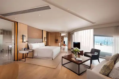 a hotel room with a bed and a living room at Conrad Manila in Manila