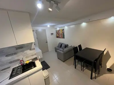 a kitchen and a living room with a table and a couch at Enzo vibes in Manila