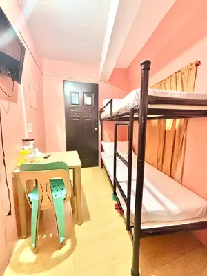 a room with two bunk beds and a table at Solano Transient House in Manila