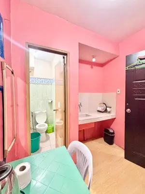 a pink bathroom with a sink and a toilet at Solano Transient House in Manila