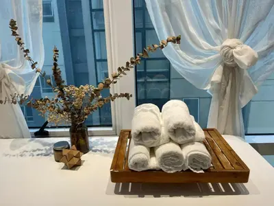 a pile of towels on a wooden tray on a table at Spacious 1BR Loft with Flex Room in BGC in Manila