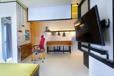 a living room with a tv and a desk with a chair at Starwars Retreat Gaming & 84 inch Movie & Near Mall in Manila