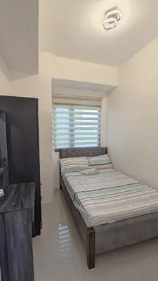 a bedroom with two beds and a window at Green 2 Residences Tower 2 Petes Place in Dasmariñas