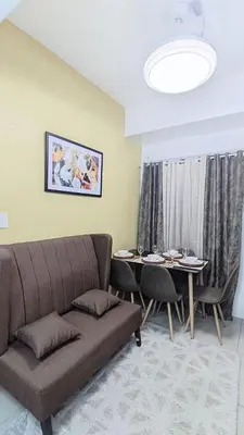 a living room with a couch and a table at Green 2 Residences Tower 2 Petes Place in Dasmariñas