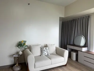 a living room with a white couch and a mirror at HomeMadeLuxury 3 Bedrooms Seaview Sunset View Near Manila Airports Okada MOA in Manila