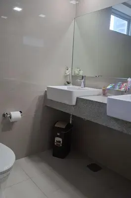 a bathroom with a sink and a mirror and a toilet at 1BR at the FORT BGC near Malls, Restaurants & Shops in Manila