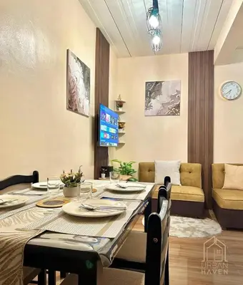 a dining room with a table and a couch at Staycation in Alabang in Manila