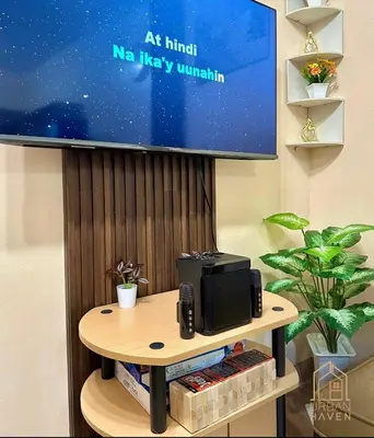 a tv screen and a table with a microwave at Staycation in Alabang in Manila