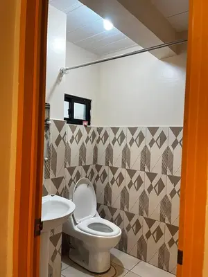 a bathroom with a toilet and a sink at Staycation in Alabang in Manila