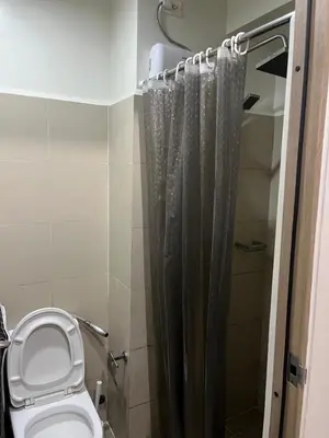 a bathroom with a toilet and a shower curtain at Smdc Coast Resideces in Manila