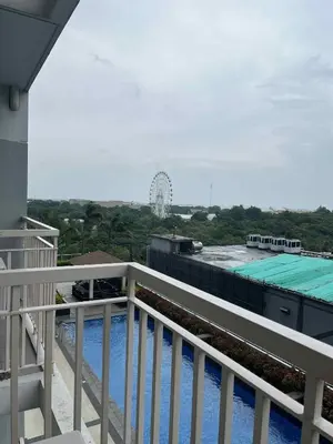 a balcony with a view of a roller coaster at Smdc Coast Resideces in Manila