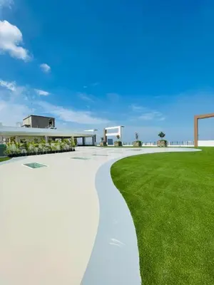 a walkway next to a green field with a building at Aston Residences 2BR in Pasay-up to 6pax in Manila