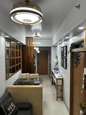 a living room with a couch and a chandelier at Shore 3 Residences with WiFi, Balcony, Pool in Manila