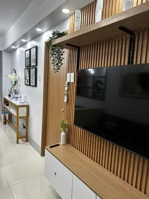 a living room with a large television on a wall at Shore 3 Residences with WiFi, Balcony, Pool in Manila