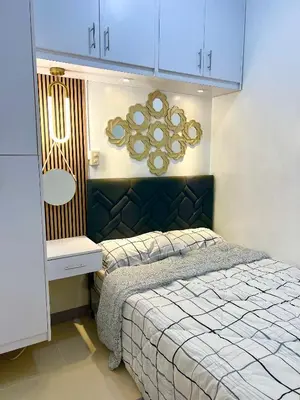 a bedroom with a bed and a mirror on the wall at Suite Serenity at S residences in Manila