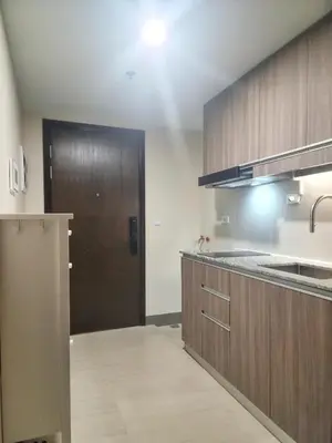 a kitchen with wooden cabinets and a brown door at Your Stylish City Escape in Park Mckinley West with Breathtaking Views in Manila